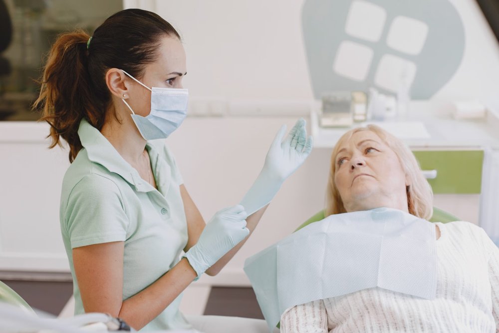 Dental professional consulting an older woman seated in a dental chair