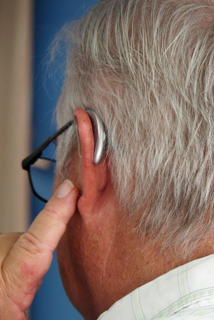 Close-up of an older man wearing a hearing aid behind his ear